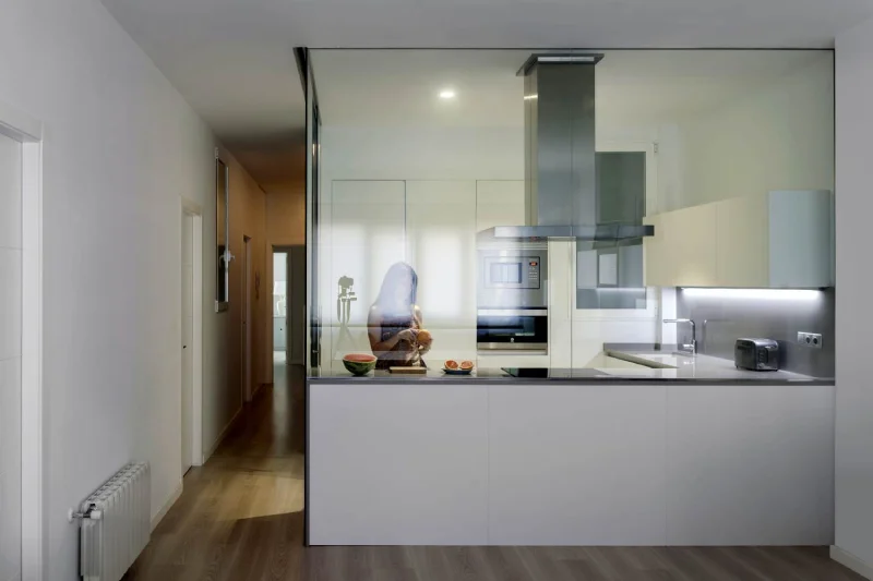 Imágen formato panorámico de una cocina modera con grandes cristaleras que deja ver el interior desde otras estancias.