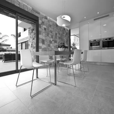 Cocina amplia y moderna con mesa comedor y con pared de piedra