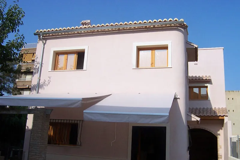 Bioconstrucción en Benimànet casa blanca estilo mediterraneo Bioconstrucción en Benimànet de una casa blanca con toldo blanco y techo de tejas.