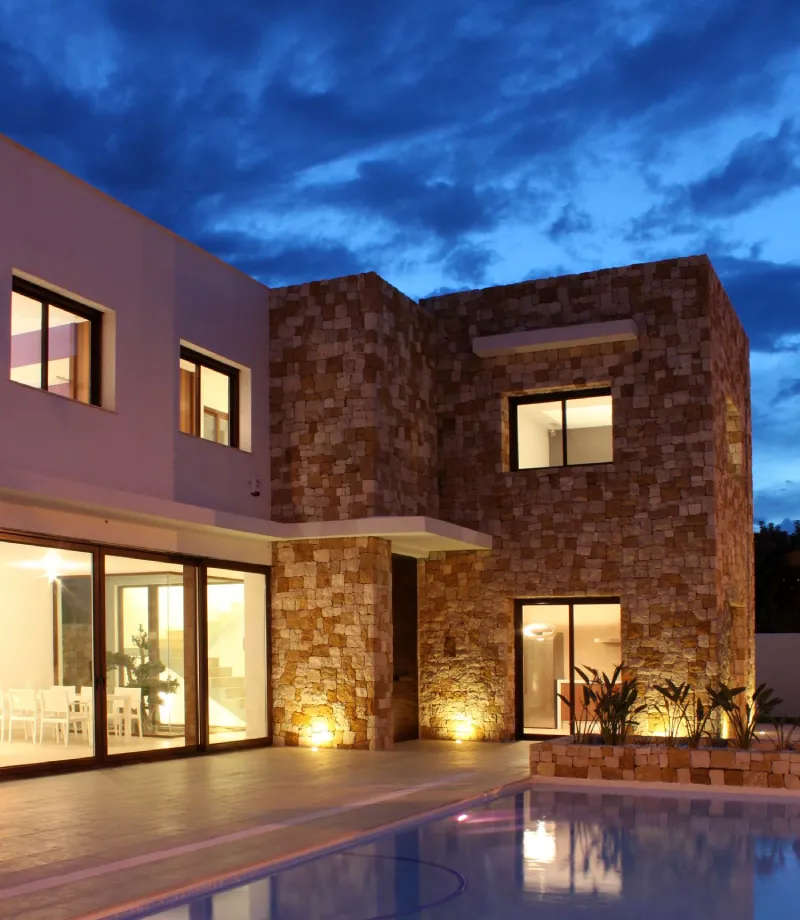 la casa Bétera iluminada en el interior y exterior desde la zona de piscina