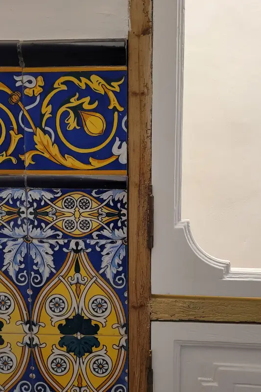 Composición azulejos y marco de ventana en casa La Silla Azulejos clásicos en pared con motivos y decoración azul, blanca y amarilla