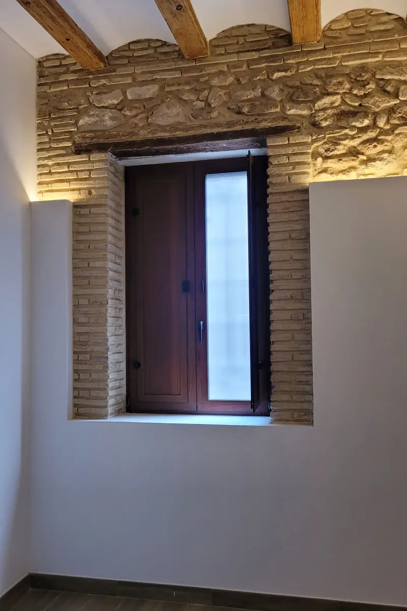 Ventana en madera en pared de piedra y ladrillo Ventana de madera moderna en pared de piedra y ladrillo en casa de pueblo La Silla