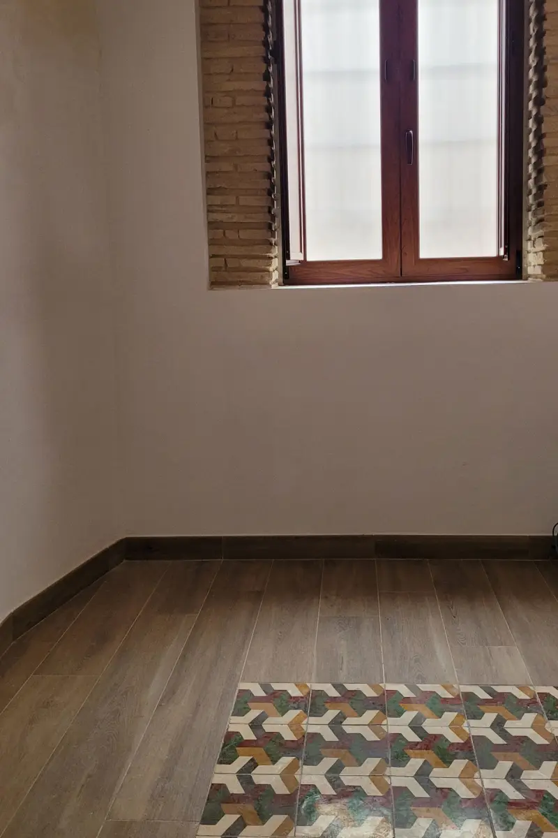 Ventana en madera en pared de ladrillo y suelo en mosáico Ventana de madera moderna en pared de ladrillo en casa de pueblo y suelo con mosáico de azulejos en casa La Silla